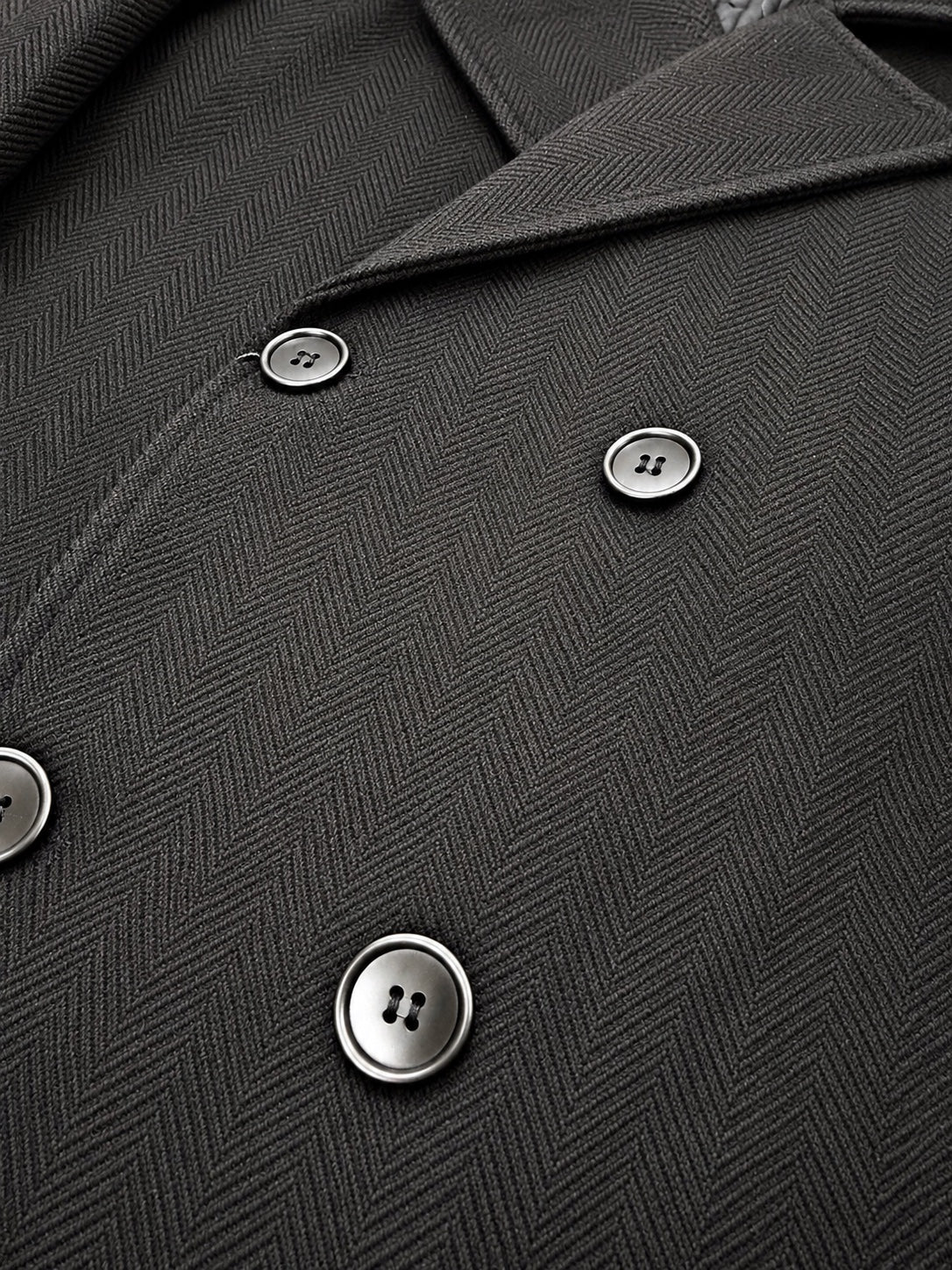 Dark herringbone overcoat fabric and button detail